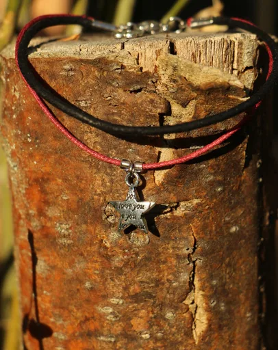 Bracelet double-rangs composé d'un lacet en cuir noir et d’une cordelette en cot