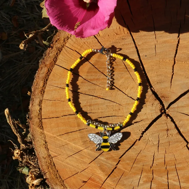 Bracelet en perles de rocaille jaunes et noires, orné d'une breloque émaillée en