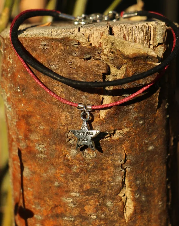 Bracelet double-rangs composé d'un lacet en cuir noir et d’une cordelette en cot